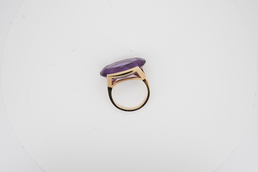 An 18k and single stone oval cut synthetic colour change corundum set dress ring, size P, gross weight 10.6 grams. Condition - good